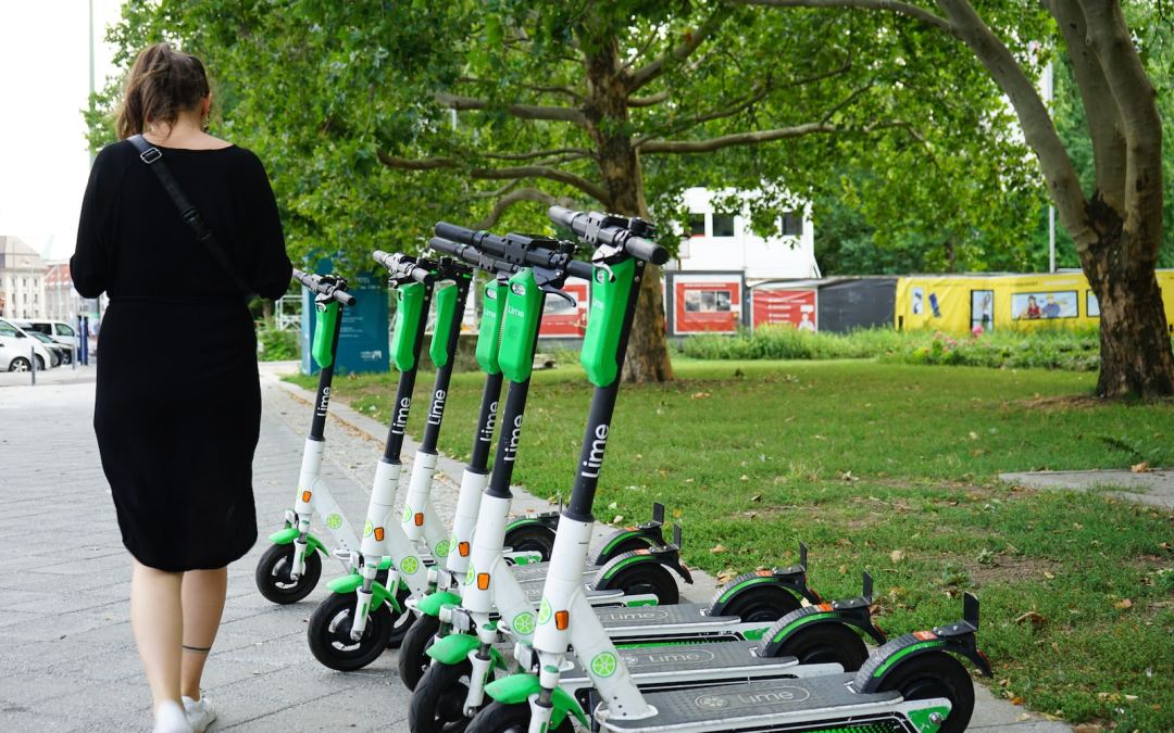 woman walking beside parked electric scooters
