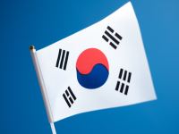 a korean flag flying in the wind with a blue sky in the background