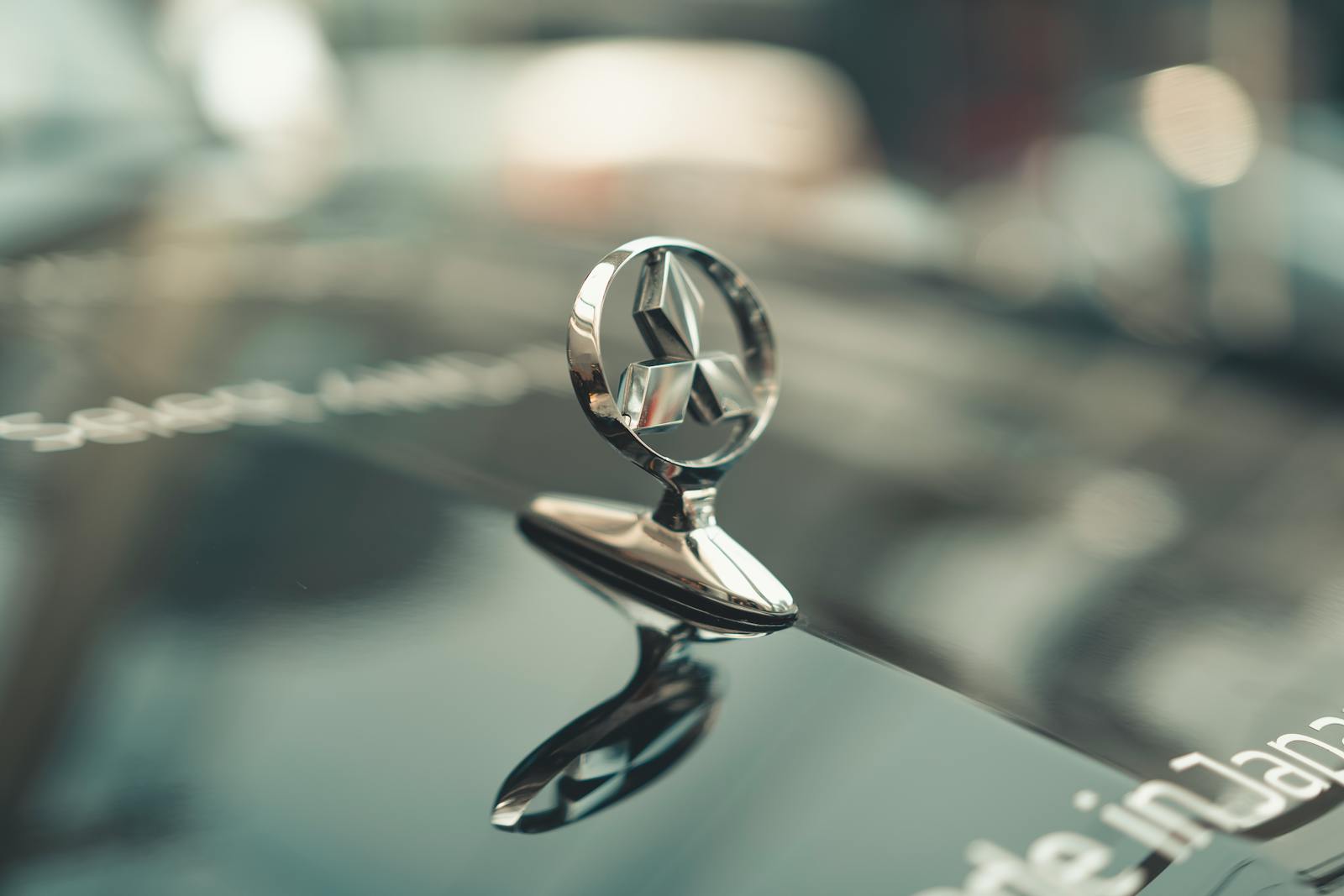 Elegant close-up view of a car emblem with shining reflection on hood.